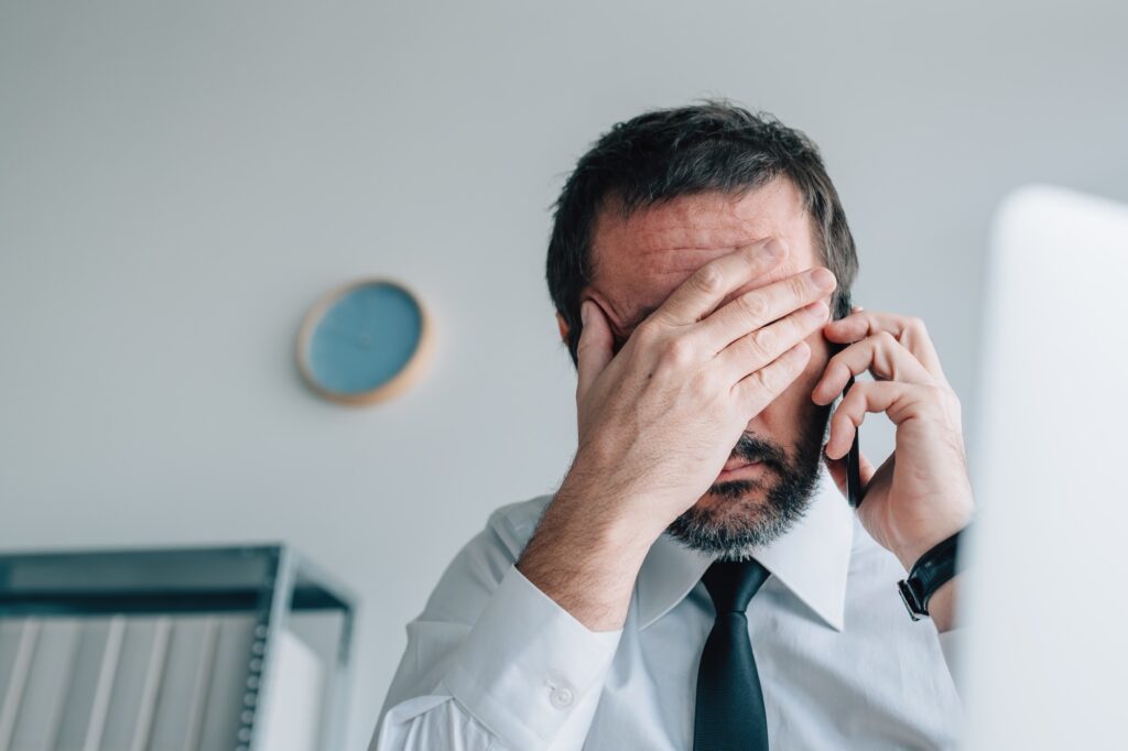 Business phone call failure, disappointed businessman using mobile phone in office